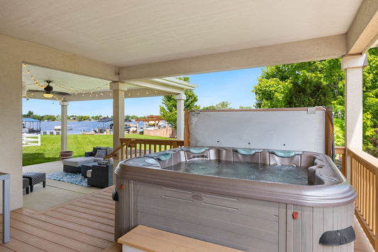 Hot tub in the backyard living space with patio furniture. - Luxe Tub Source