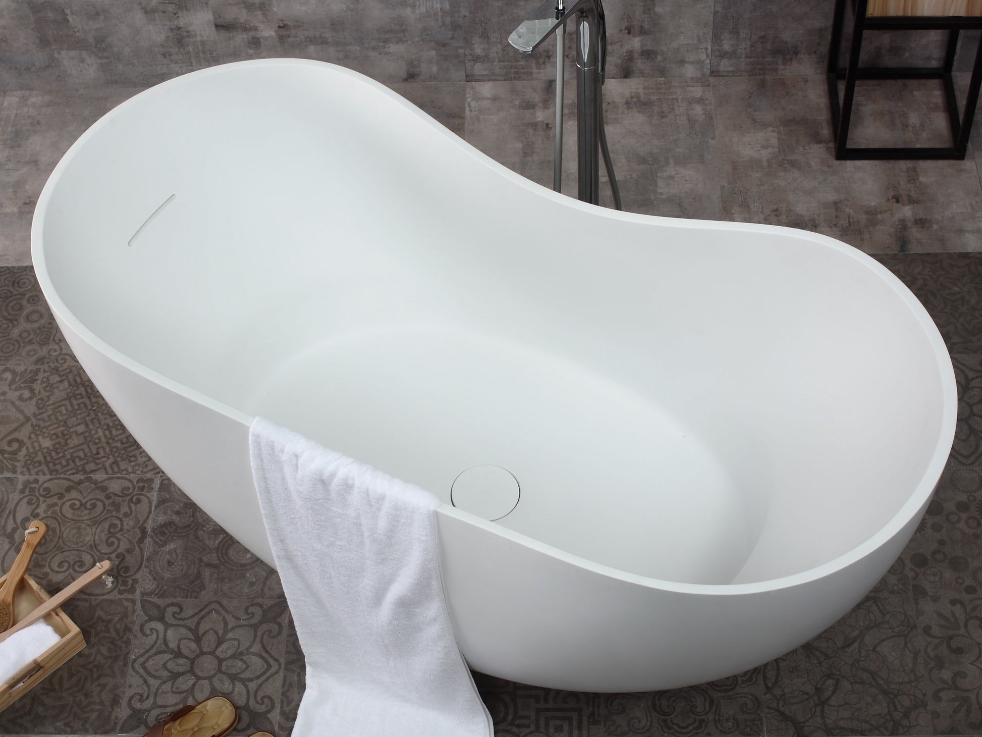 ALFI Brand top angled view of a White freestanding bathtub with a towel draped over it in a bathroom setting. - Luxe Tub Source
