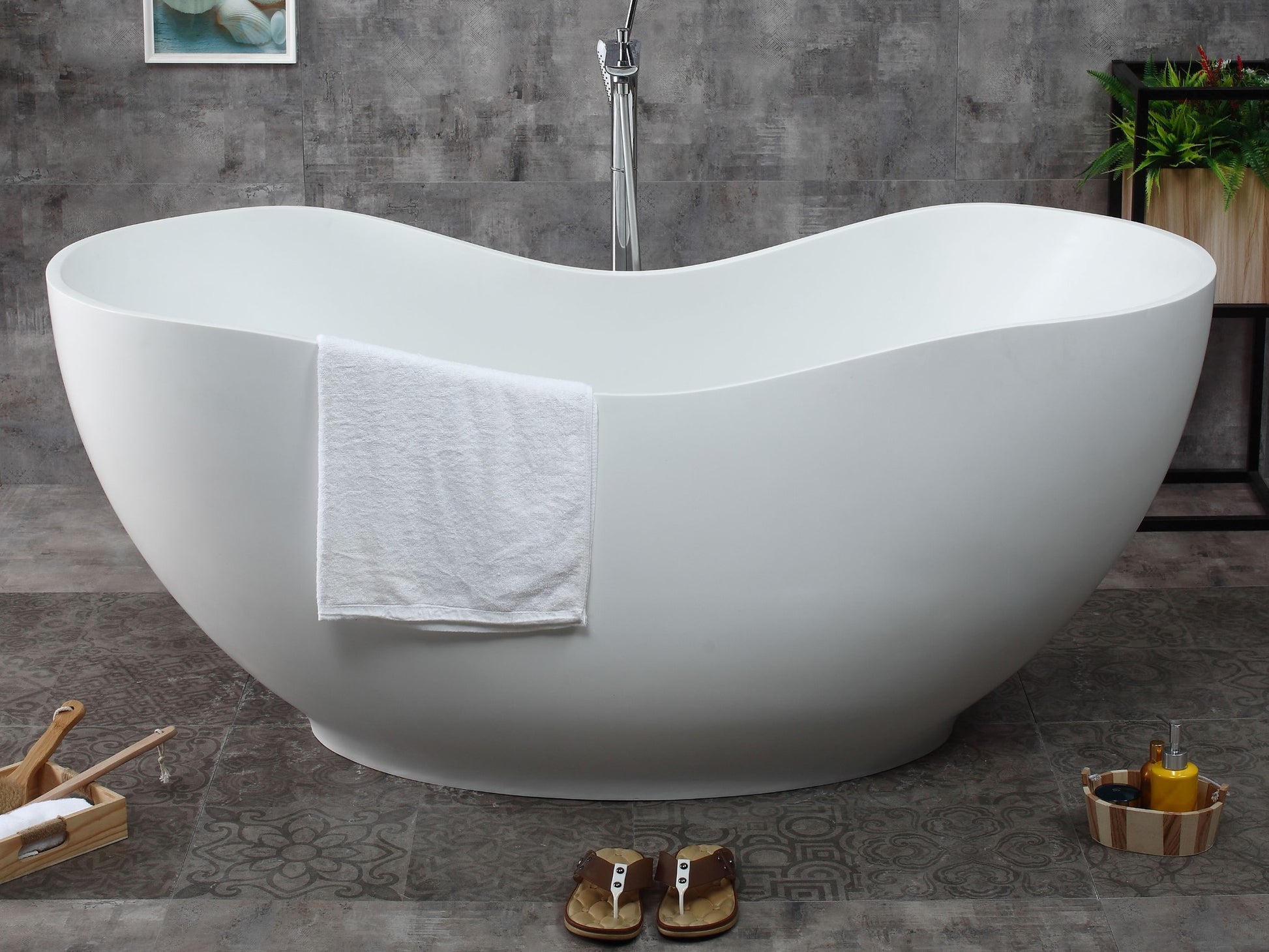 ALFI Brand White freestanding bathtub in a bathroom with a towel draped over it and sandles on the floor. - Luxe Tub Source