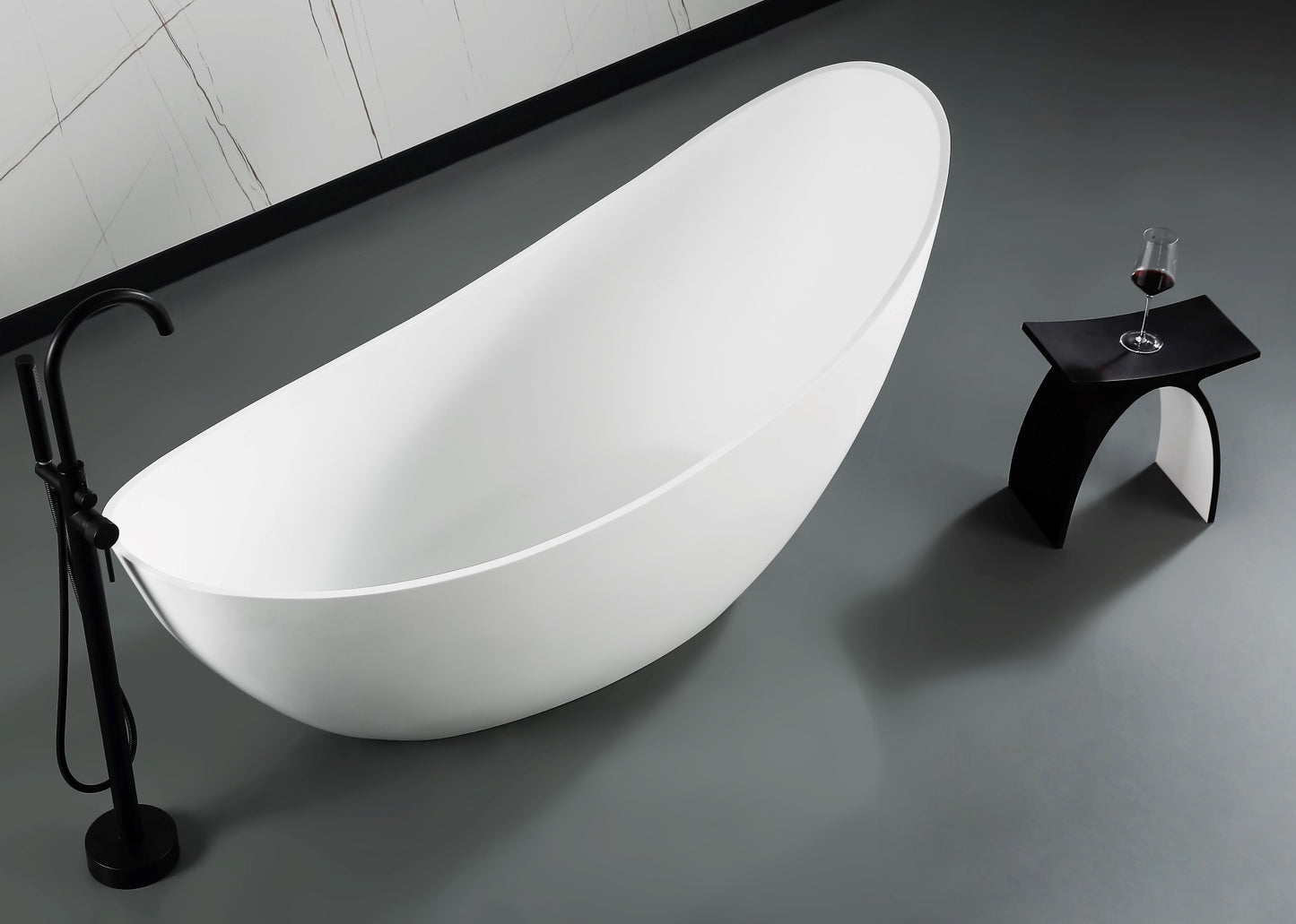 ALFI Brand Modern freestanding bathtub in a bathroom setting with a glass of wine on a stool. - Luxe Tub Source