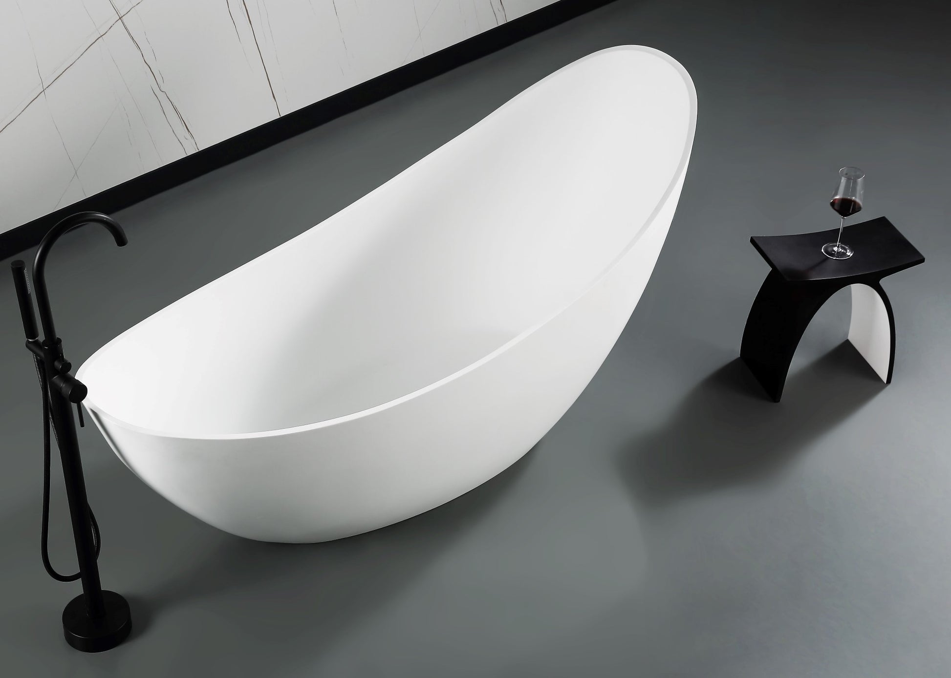 ALFI Brand Modern freestanding bathtub in a bathroom setting with a glass of wine on a stool. - Luxe Tub Source