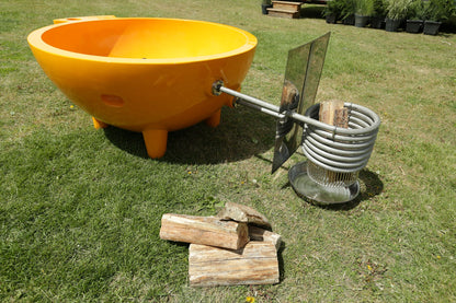 ALFI Brand Yellow Outdoor Wood-Burning Hot Tub with a metal coil and wooden logs on grass  - Luxe Tub Source
