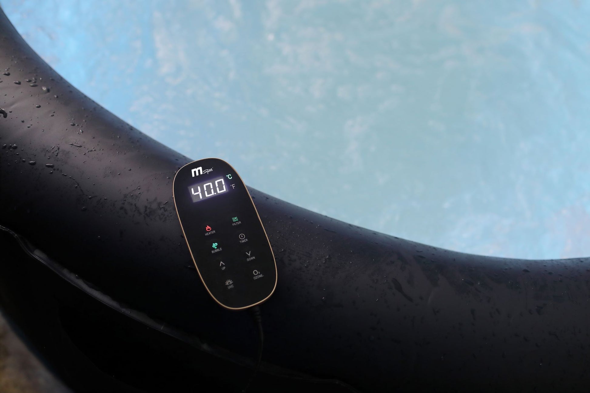 Hot tub remote control sitting on the edge of the hot tub.
