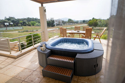 MSpa Hot tub on a patio with outdoor furniture and scenic view.  - Luxe Tub Source