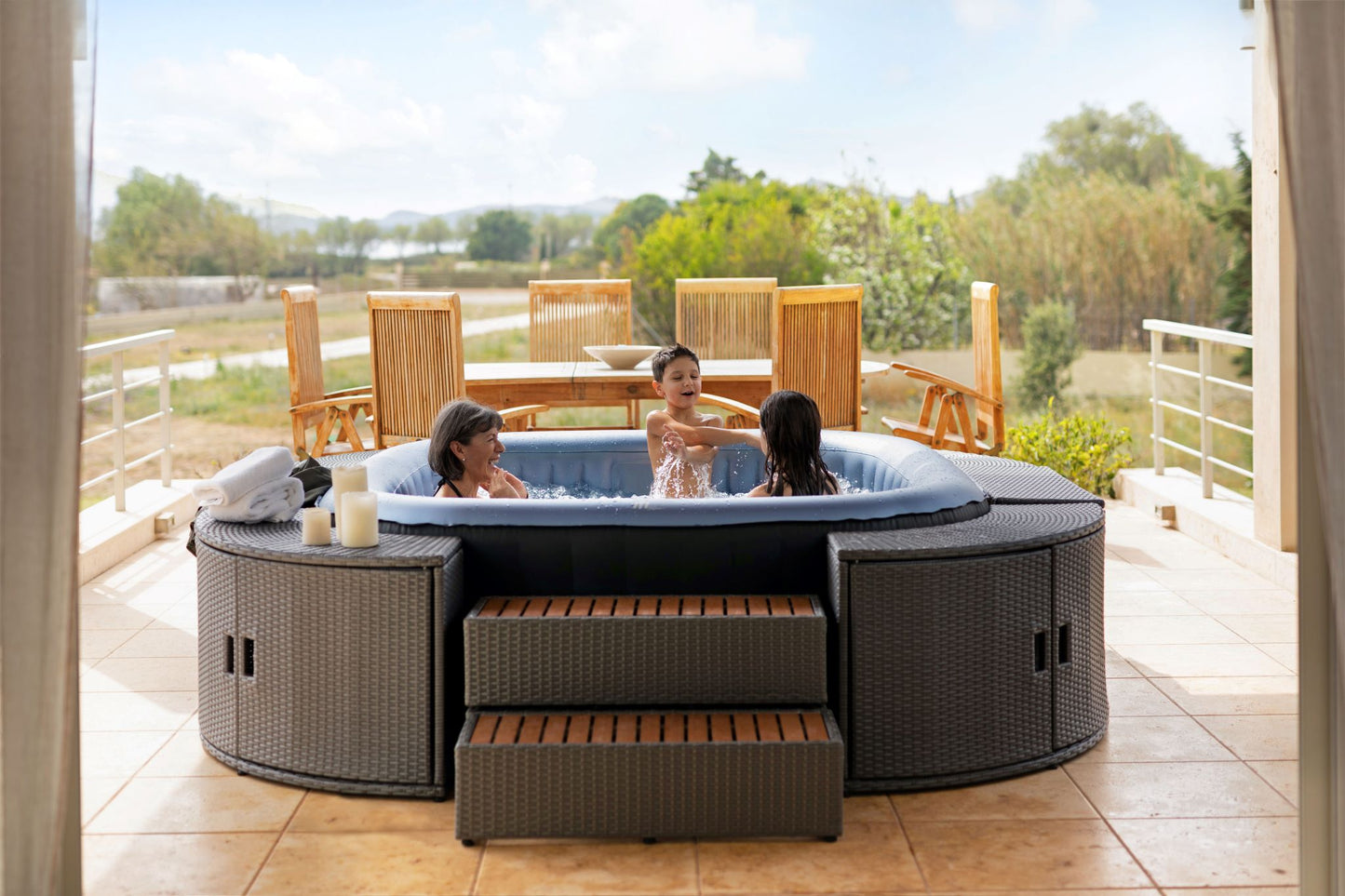 MSpa Children enjoying a hot tub on a sunny day with a scenic background.  - Luxe Tub Source