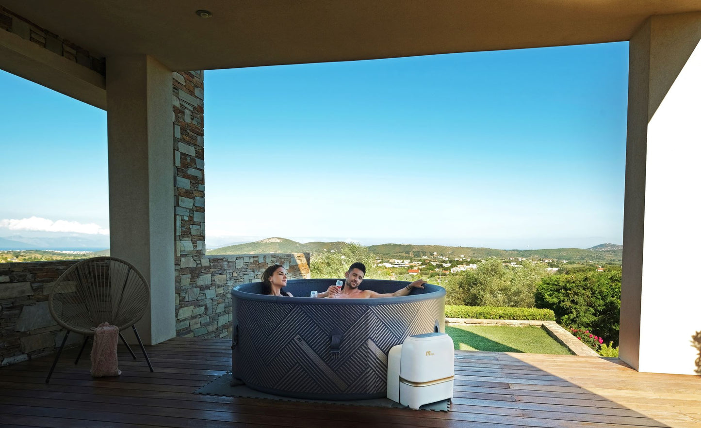 MSpa Two people in a hot tub on a wooden deck with a scenic view. - Luxe Tub Source