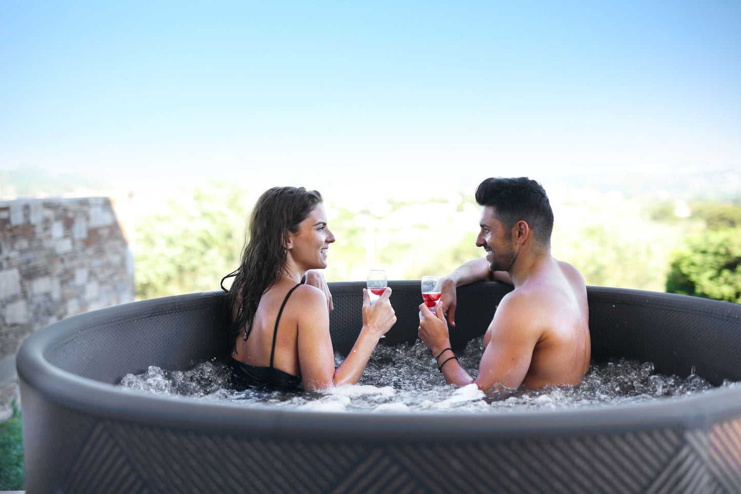 MSpa Couple in a hot tub enjoying each other's company with drinks. - Luxe Tub Source
