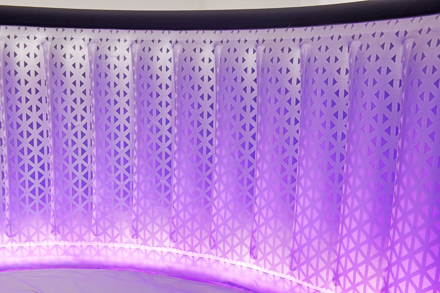 The interior of the Mspa Aurora hot tub illuminated by purple LED lights.
