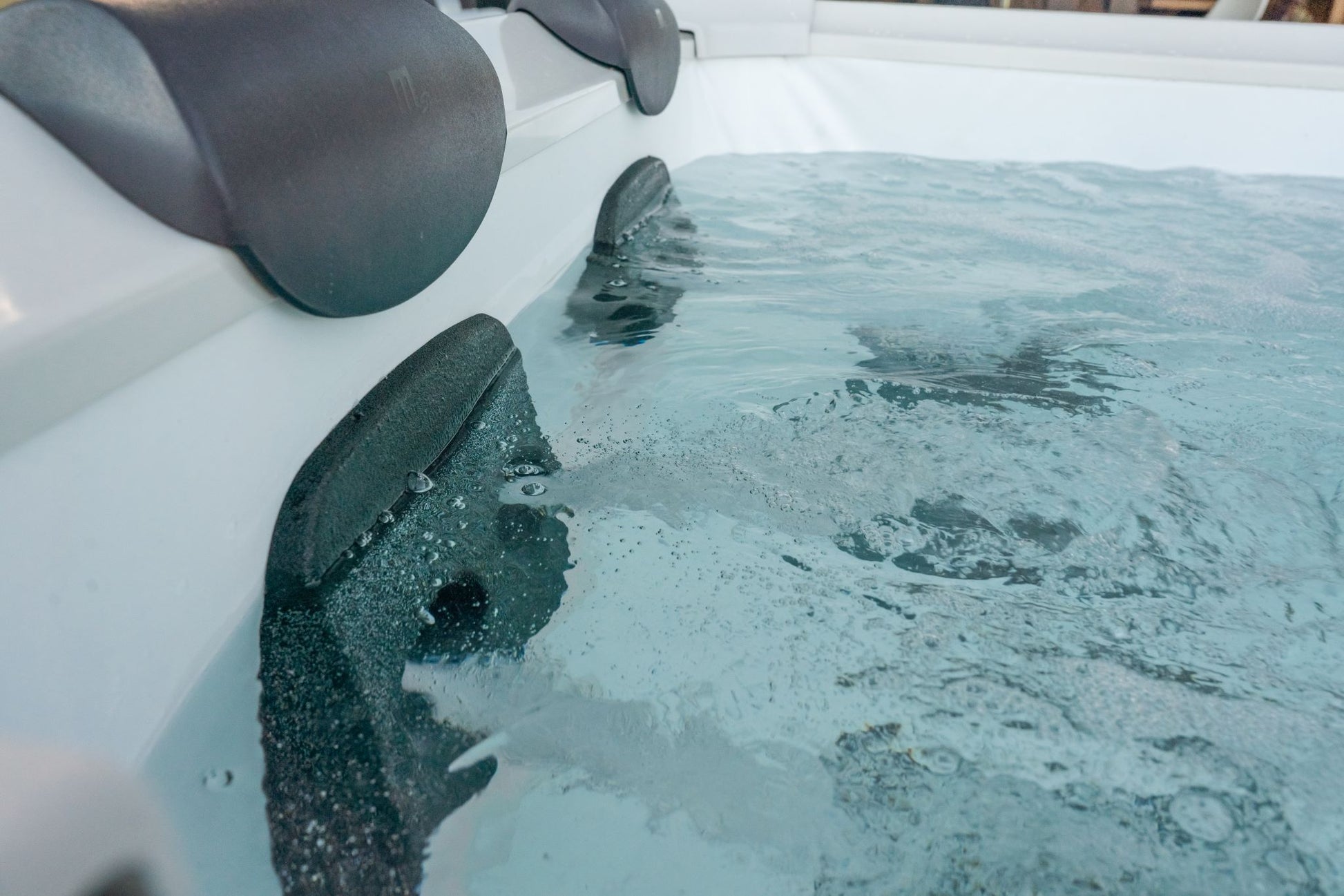 Hot tub with water and head rests.